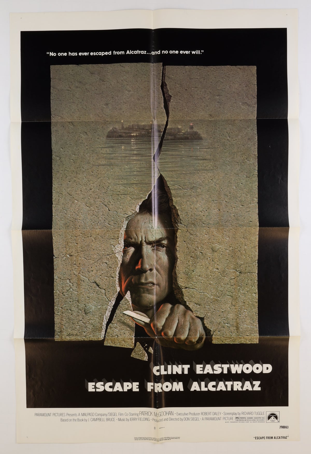 Front of an original 1979 U.S. one sheet movie poster for Escape from Alcatraz, featuring Clint Eastwood breaking through a cracked concrete wall with Alcatraz Island visible in the background.
