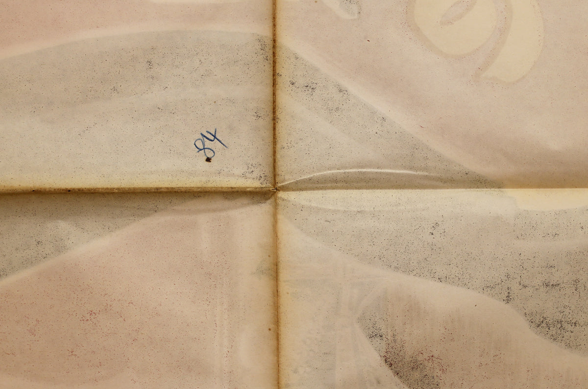 Close-up of the reverse showing fold intersections, surface spotting, faint bleed-through, and a small handwritten marking.
