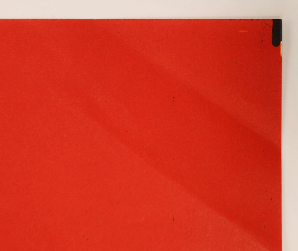 Close-up of red background area on The Lost Boys French poster showing minor surface marks and edge wear.