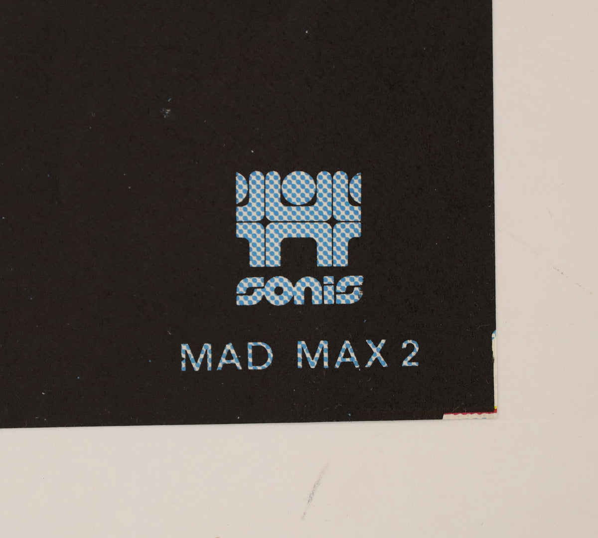 Close-up of lower corner of French Mad Max 2 poster showing LANDI by SPADEM 1982 copyright mark and edge wear