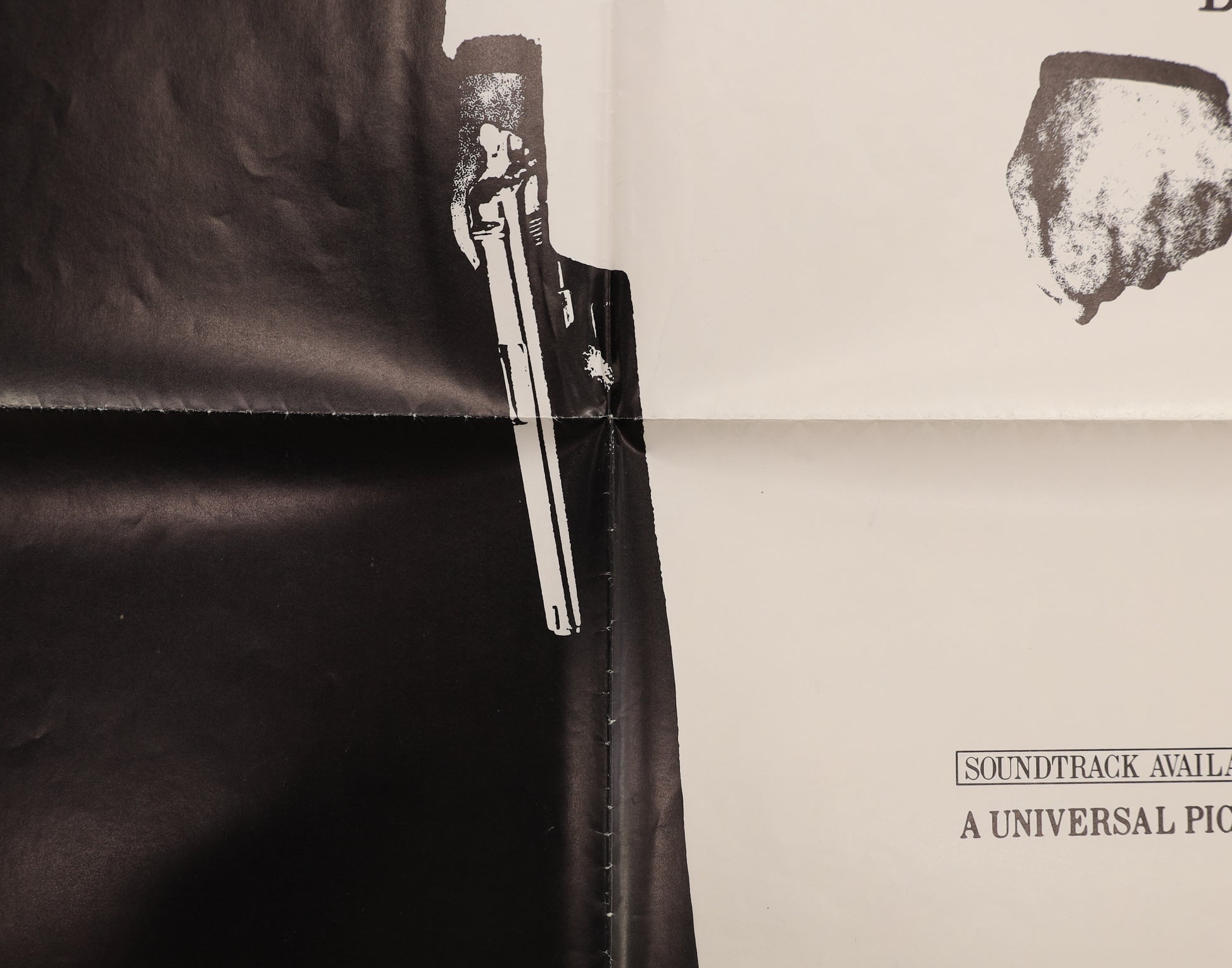 Close up image of the intersecting fold lines on a scarface one sheet poster detailing al's hand carrying a gun.