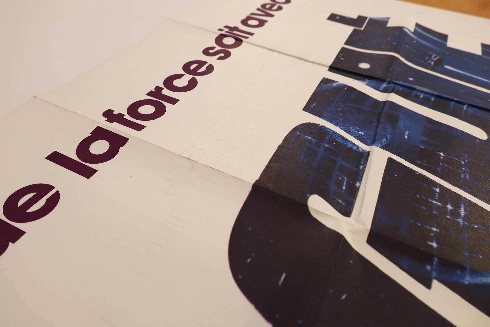 Close-up of the Star Wars 1977 French double panel poster showing visible ink transfer and surface wear near the upper lettering and fold lines.